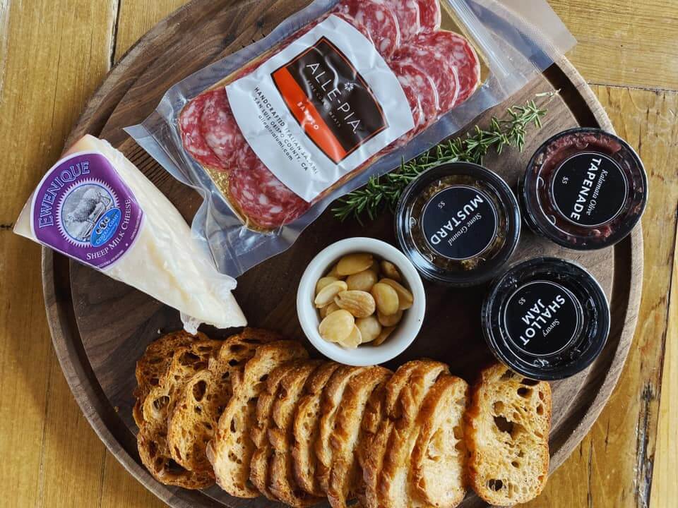 Our cheeseboard, complete with Crostini, Cheese, salami, shallot jam, tapenade, mustard, marcona almonds and rosemary