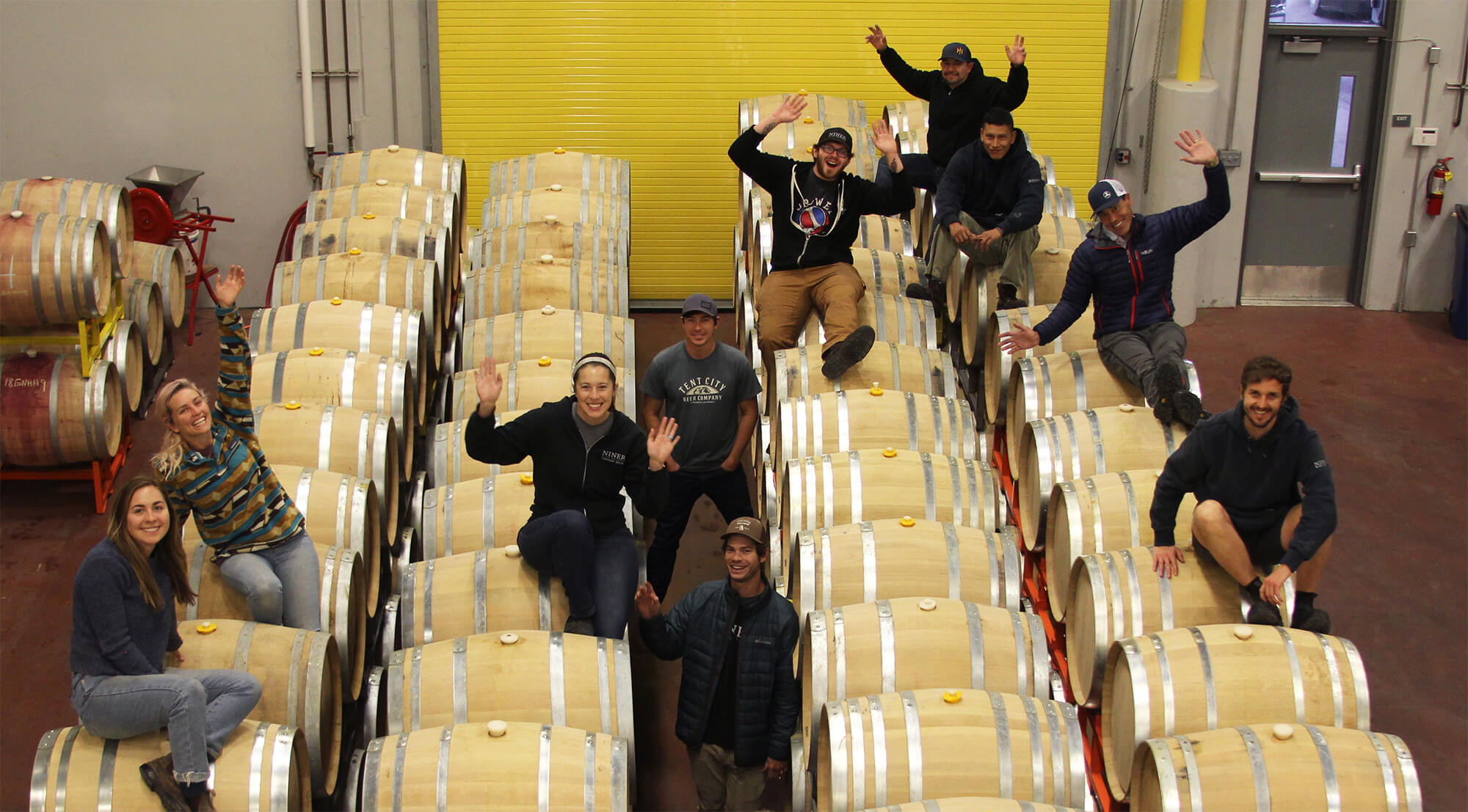 Our Cellar team posing on rows of barrels