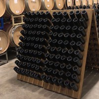 Riddling rack full of bottles and barrels in the winery